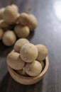 Langsat, Longkong, placed in a wooden cup set on a wooden board table dark blurred background Royalty Free Stock Photo