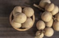 Langsat, Longkong, placed in a wooden cup set on a wooden board table dark blurred background Royalty Free Stock Photo
