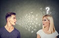 Language barrier concept. Handsome man talking to an attractive woman with question mark Royalty Free Stock Photo