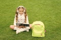 Language learning course. Girl child learn English sitting on green grass. Foreign language. Audio lesson Royalty Free Stock Photo