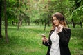 Language Learning, online study concept. Young girl in headphones and with a smartphone learns a foreign language in the park