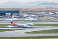 Cargolux airplane is landing in runway, passenger airplanes are parking at maintenance