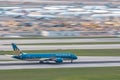 Vietnam Airlines airplane is running for take off at runway, all parking space is fully