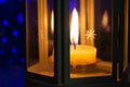 Lantern with burning candle in dark. Behind blue bokeh. Holiday atmosphere, Christmas, New Year Royalty Free Stock Photo