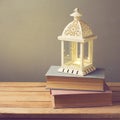 Lantern with candle and vintage books on wooden table. Christmas Celebration Royalty Free Stock Photo