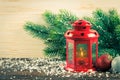 Lantern and Christmas tree over snow on wooden background Royalty Free Stock Photo
