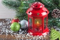 Lantern and Christmas tree over snow on wooden background Royalty Free Stock Photo