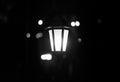 Lantern in the dark. Burning lantern in the dark. Electric lamp. Black and white photo.