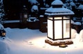 A lantern illuminates a heavy snow covered table alfresco in the winter snow