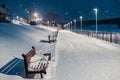 Lantern lighting in winter, snowfall and snow-covered benches