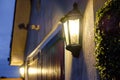 Security lantern seen outside and large house and garage.