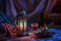 Lantern-lit Table: A cozy Middle Eastern tableau with a lantern casting patterned shadows, showcasing tea, dates, and Royalty Free Stock Photo