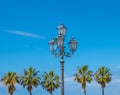 Lantern and palm trees against the blue sky. Panoramic terrace in the south of the Tyrrhenian Sea in the mountain village of Royalty Free Stock Photo