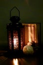 The lantern of Ramadan is black in color, luminous, decorated with wooden motifs, next to the Holy Quran