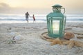 Lantern with shells on beach and soft focus father and son collecting shells at sunrise