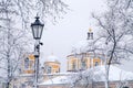 Lantern in the snow on the background of snowy trees and the city