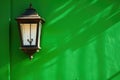 a lantern style porch light against a green, painted wall