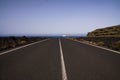 Lanzarote - Timanfaya NP: Driving trip on endless empty asphalt road between black lava rocks in barren landscape to atlantic