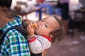 Lao Cai, Vietnam - Sep 7, 2017: Ethnic minority child on her mother back at local market in Y Ty, Bat Xat district Royalty Free Stock Photo