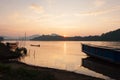 Laos fisherman with fishing wooden boat in the Mekong River at sunset. Simple life. Traditional Laos boat foregrounds. Beautiful Royalty Free Stock Photo