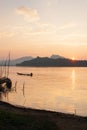 Laos fisherman with fishing wooden boat in the Mekong River at sunset. Simple life. Traditional Laos boat foregrounds. Beautiful Royalty Free Stock Photo