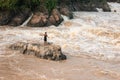 Laos fisherman standing on the rock in rapids of Li Phi Waterfall. Li Phi Waterfall is one of the highlights of the 4,000 Islands