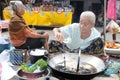 Laos: A old woman coocking fish soup on the market in Luang Brabang Royalty Free Stock Photo