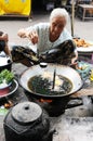 Laos: A old woman coocking fish soup on the market in Luang Brabang Royalty Free Stock Photo