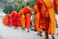 Laotian Buddhist monks walking along the street during alms giving ceremony in Luang Prabang, Laos Royalty Free Stock Photo