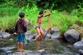 Laotian children fisher using fishing net catch fish in stream Royalty Free Stock Photo