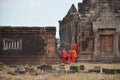 Laotian monk and novice visit with pray buddha and god statue at Vat Phou