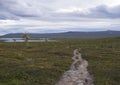 Lapland landscape with Kungsleden hiking trail in northern Sweden. Wild nature with Kaskajaure lake, mountains, autumn colored