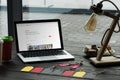 laptop with airbnb website on table with macarons coffee and sale tags