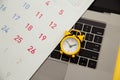 Laptop and alarm clock, monthly calendar on yellow background. Time running away Royalty Free Stock Photo