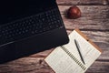 Laptop apple and a notebook on a wooden desk