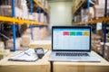 Laptop and barcode scanner on boxes in a warehouse.