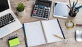 Laptop, blank notepad, pen calculator, reminder flower on office table Royalty Free Stock Photo