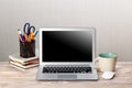 Laptop with blank screen, cup of coffee and books or notebooks on a wooden table. mockup for your text Royalty Free Stock Photo