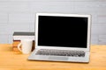 Laptop with blank screen, cup of coffee and books or notebooks on a wooden table. mockup for your text Royalty Free Stock Photo