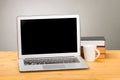 Laptop with blank screen, cup of coffee and books or notebooks on a wooden table. mockup for your text Royalty Free Stock Photo