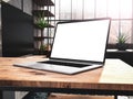 Laptop with blank screen mockup template on table in industrial old factory loft interior