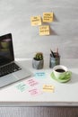 Laptop with blank screen and paper stickers and cup of coffee on tabletop Royalty Free Stock Photo