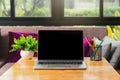 Laptop with blank screen, pencils, vase on table in home office. Workspace with laptop and office supplies Royalty Free Stock Photo