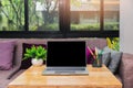 Laptop with blank screen, pencils, vase on table in home office. Workspace with laptop and office supplies Royalty Free Stock Photo