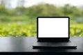 Laptop with blank screen on table, Conceptual workspace, Laptop computer with blank white screen on table, Green blurred backgroun