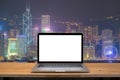 Laptop with blank screen on table. hongkong night city background.