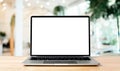 Laptop blank screen on wood table with blurred coffee shop cafe interior background Royalty Free Stock Photo