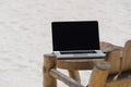 Laptop blank screen on wooden desk with beach. relax concept. Royalty Free Stock Photo