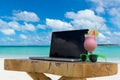 Laptop blank screen on wooden desk with beach. relax concept. Royalty Free Stock Photo