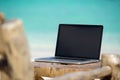 Laptop blank screen on wooden desk with beach. relax concept. Royalty Free Stock Photo